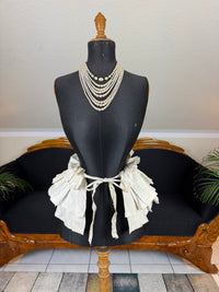 Victorian white linen four‑tier bustle pad c.1898 with pleated tiers and cotton waist tie.