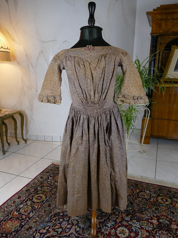 1845 Biedermeier girl’s dress in printed cotton with puffed sleeves and gathered skirt, antique children’s gown