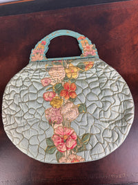 Antique quilted silk beach bag with hand‑painted wooden handles and floral appliqué.
