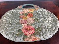 Antique quilted silk beach bag with hand‑painted wooden handles and floral appliqué.