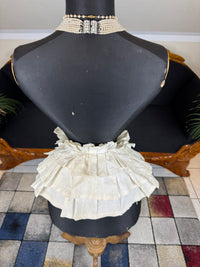 Victorian white linen four‑tier bustle pad c.1898 with pleated tiers and cotton waist tie.