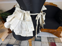 Victorian white linen four‑tier bustle pad c.1898 with pleated tiers and cotton waist tie.