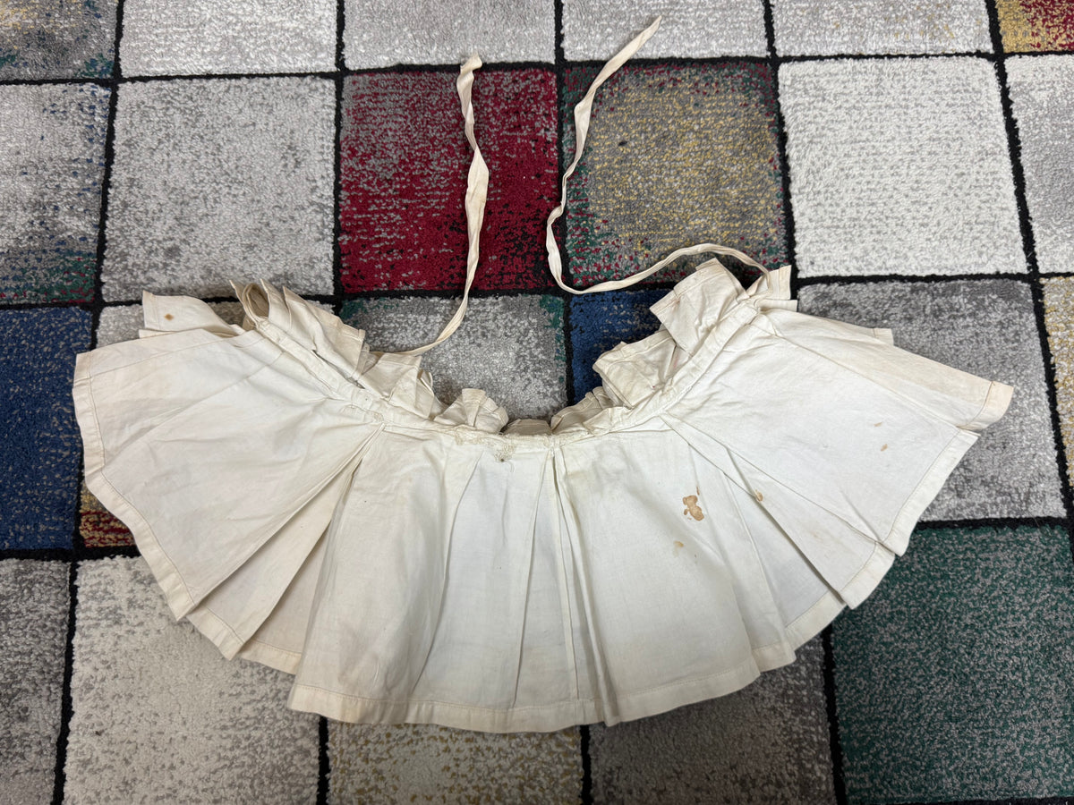 Victorian white linen four‑tier bustle pad c.1898 with pleated tiers and cotton waist tie.