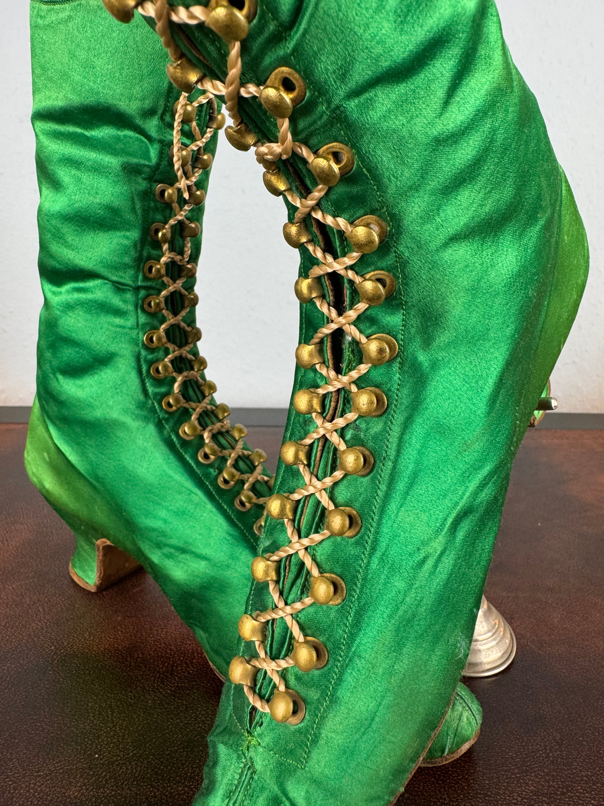 Victorian green silk lace‑up boots, c.1875, with brass fasteners, red leather lining and vivid aniline‑dyed colour