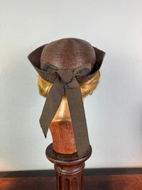 Small French brown straw hat with two back ribbons, sailor‑style shape, well preserved