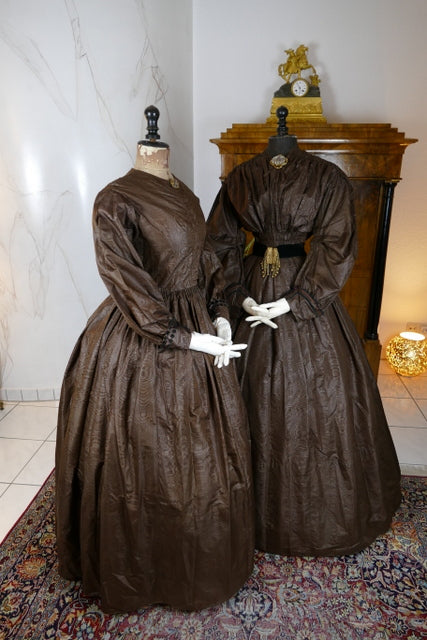 1840s Biedermeier mother‑daughter afternoon dresses in printed cotton with wide sleeves and fitted bodices, antique gowns