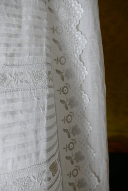 Early 20th‑century christening gown with tie closure and fine embroidery
