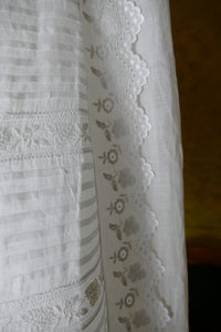 Early 20th‑century christening gown with tie closure and fine embroidery