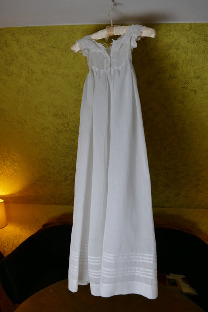 Early 20th‑century christening gown with tie closure and fine embroidery